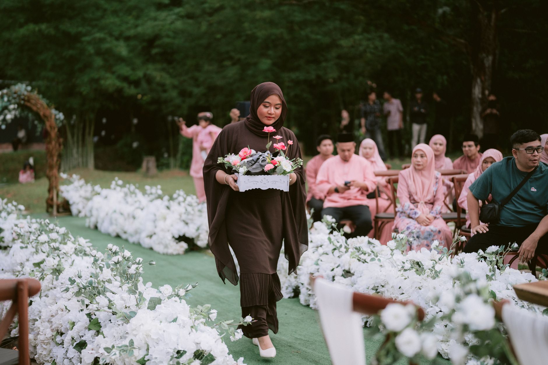 Karangan bunga pernikahan elegan dengan mawar putih dan hijau, melengkapi dekorasi resepsi romantis