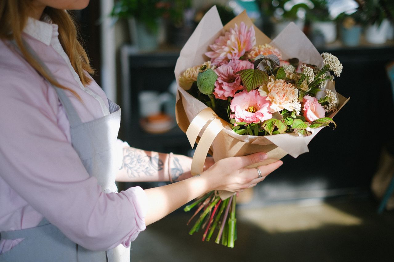 Mastering the First Impression: Your intriguing post title goes here Close-up of a florist holding a colorful bouquet of flowers indoors, showcasing floral elegance.